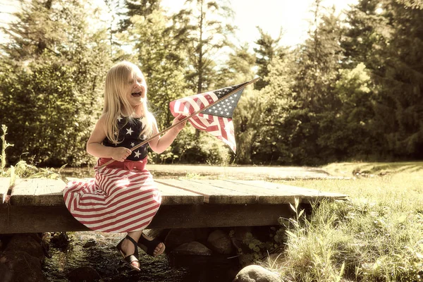 Lycklig liten flicka med amerikanska flaggan på självständighetsdagen — Stockfoto