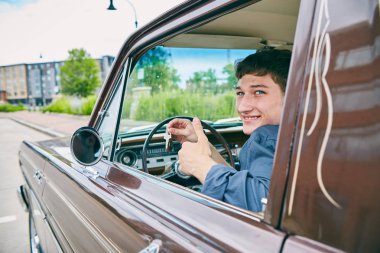 Mutlu erkek sürücü tuşları açık araba penceresinde gösterilen