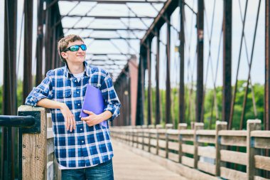 Klasör tutan güneş gözlüğü gülümseyen genç adam