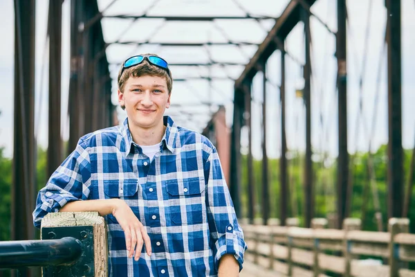 Köprüde duran gülümseyen genç adam portresi