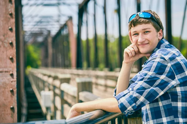 Köprüde duran ve gülümseyen pozitif genç adam