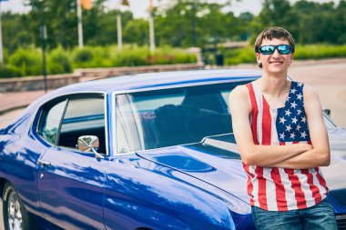 Gülümseyen genç beyaz adam arabasına ayakta