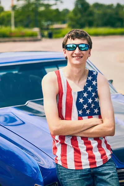 Positieve jonge Amerikaanse jongen permanent bij zijn auto — Stockfoto