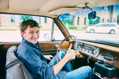 Arabada oturan ve başparmak gösterilmesini mutlu adam