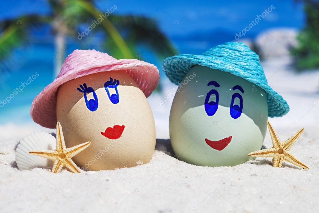 Two eggs with faces on beach
