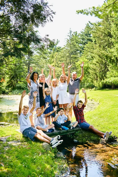 Glückliche große Familie steht auf Brücke und winkt — Stockfoto