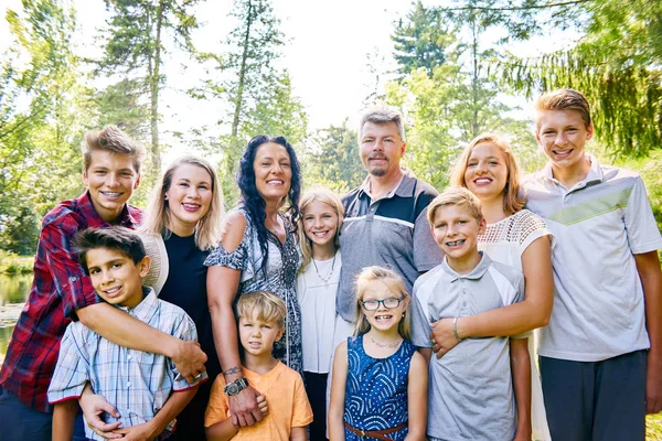 Porträt einer glücklichen elfköpfigen Familie, die im Park posiert — Stockfoto