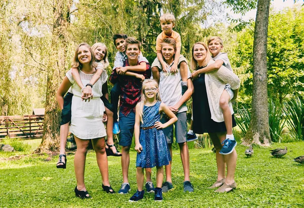 Adult siblings with little sisters and brothers — Stock Photo, Image