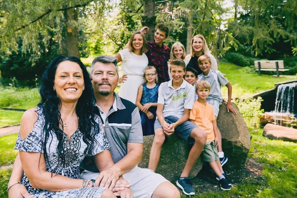 Glückliches Ehepaar mit neun Kindern im Park — Stockfoto