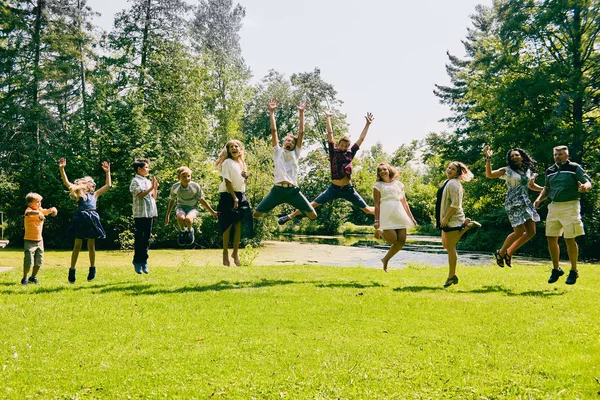 Des enfants heureux sautant avec leurs parents — Photo