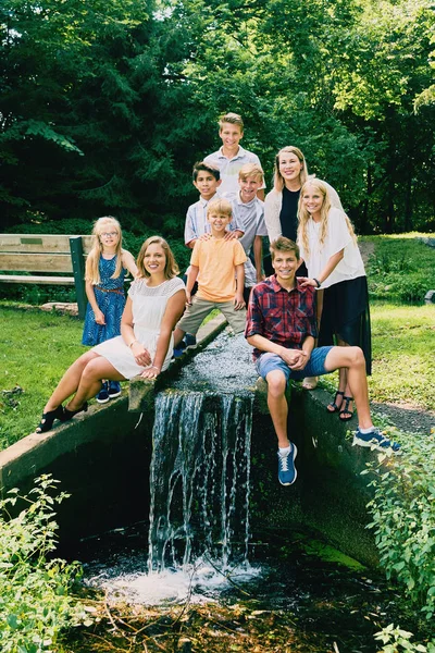 Glada syskon eller vänner sitter vid floden — Stockfoto