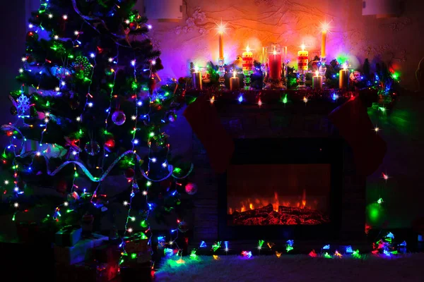 Árbol de Navidad cerca de la chimenea en habitación decorada — Foto de Stock