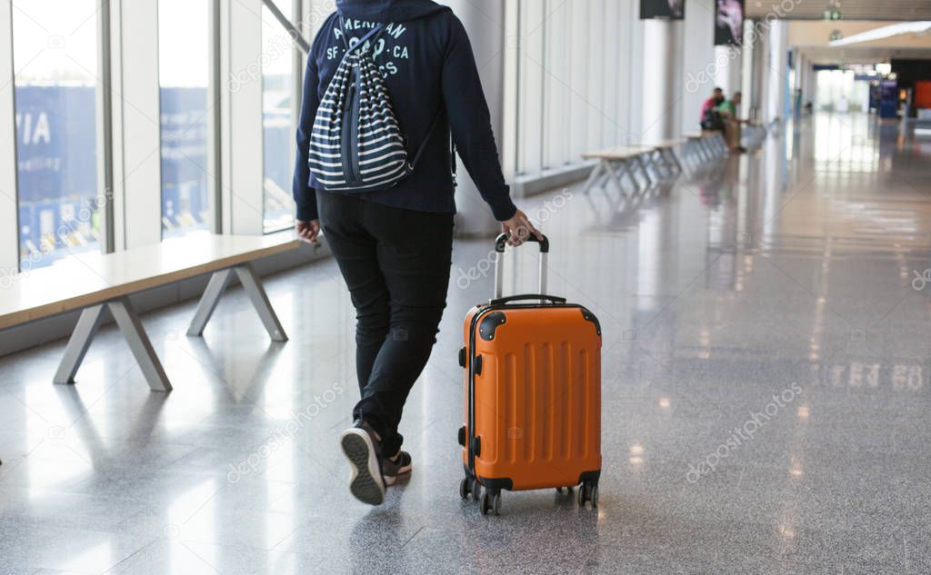 Close-up of a woman passenger walking with suitcase