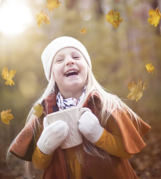 快乐的小女孩在干枯的树叶中嬉笑的画像 — 图库照片