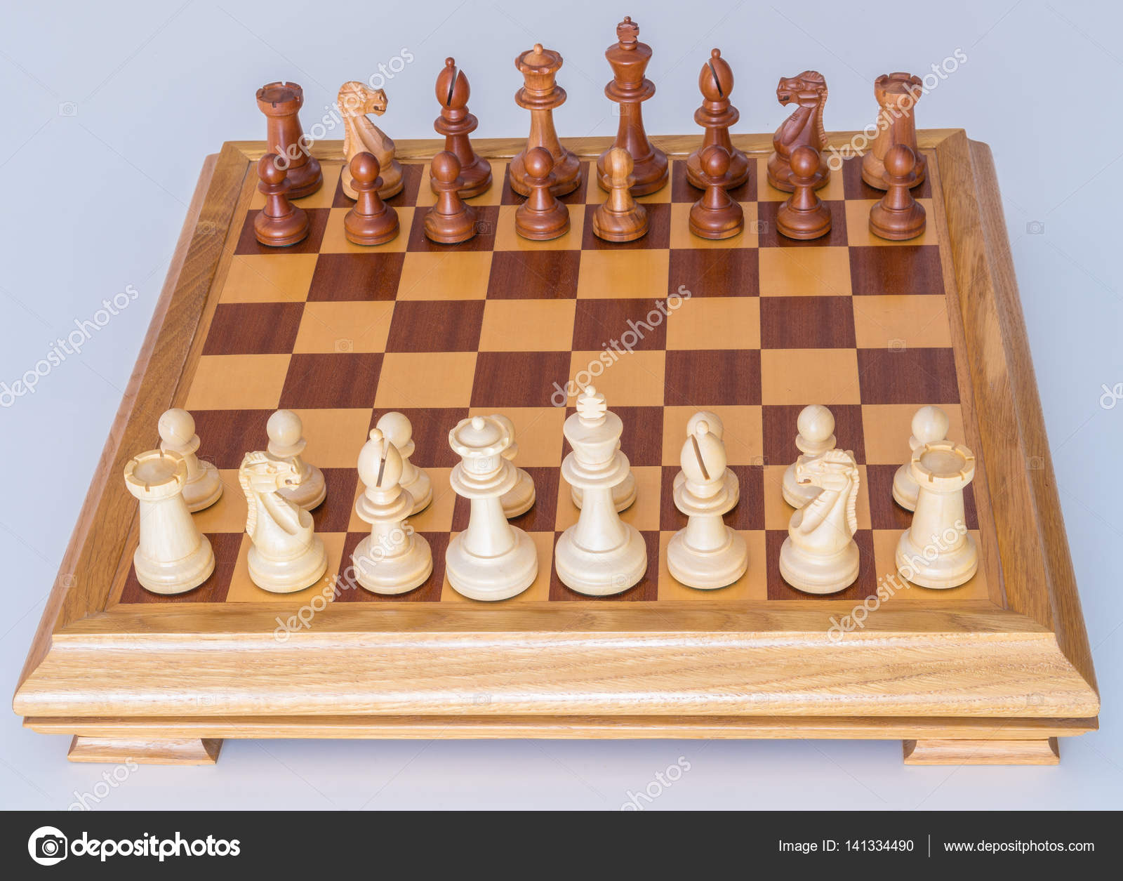 Chess pieces in starting position on a wooden Board Stock Photo by  ©Rostislavv 141334490