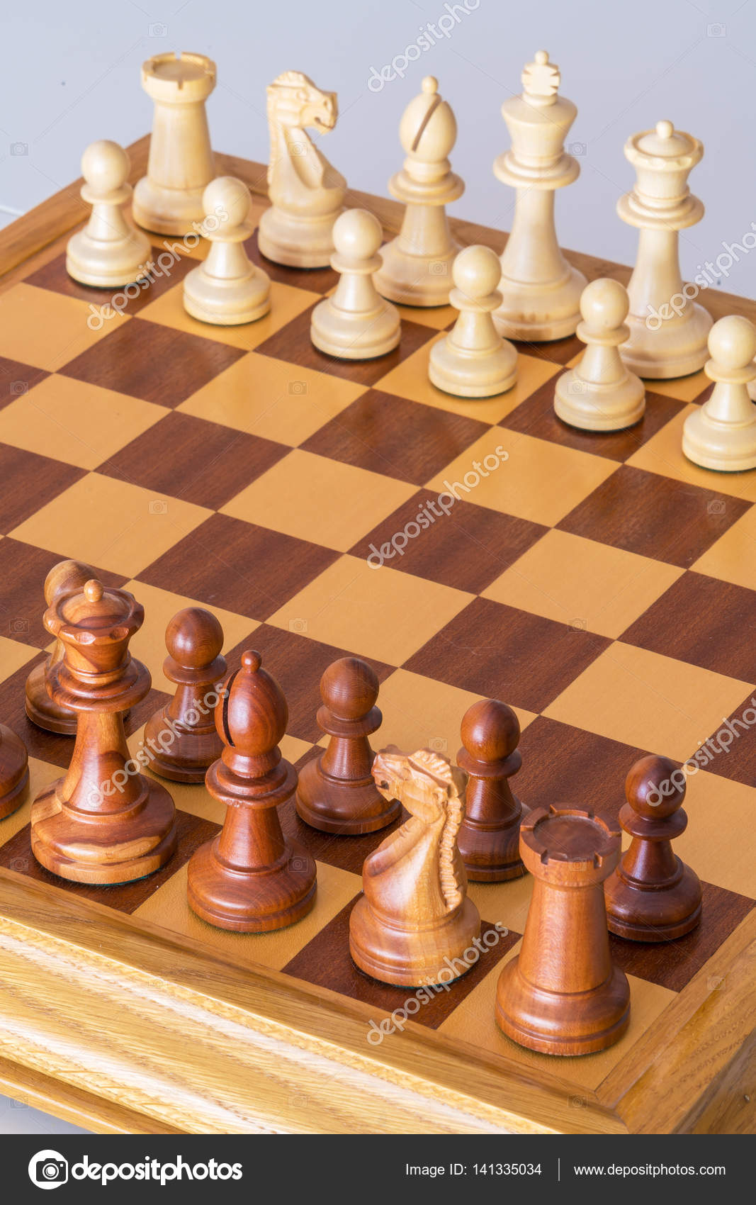 Chess pieces in starting position on a wooden Board Stock Photo by  ©Rostislavv 141335034