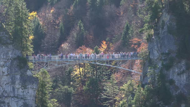 Touristen stehen auf der Marienbrücke nahe Schloss Neuschwanstein — Stockvideo