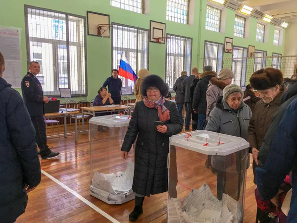 Москва, Россия - 18 марта 2018 года: Избиратель ставит бюллетень в урну для голосования на выборах президента — стоковое фото