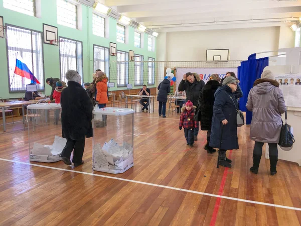 Москва, Россия - 18 марта 2018 года: Избиратель ставит бюллетень в урну для голосования на выборах президента — стоковое фото