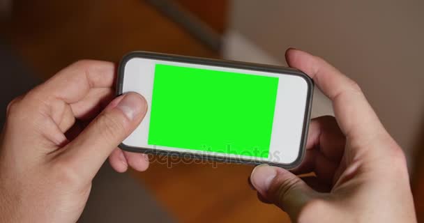 Hombre utiliza la pantalla verde en blanco Smartphone para jugar un juego — Vídeos de Stock