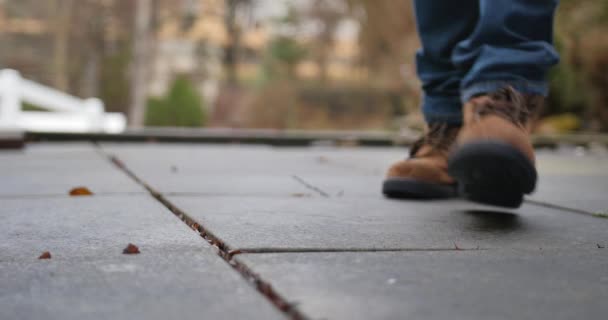 Человек, сбрасывающий стальные трубы на ноги на строительной площадке — стоковое видео
