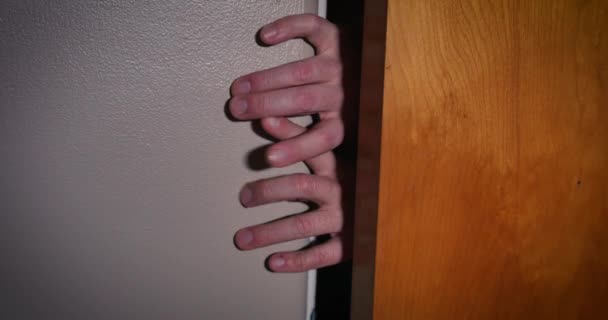 Dedos semelhantes a zumbis tentam entrar no quarto por trás da porta fechada — Vídeo de Stock