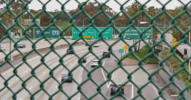 Langsam Dolly Schuss Blick auf die Autobahn 5 Verkehr durch Zaun — Stockvideo