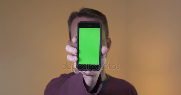Hombre sostiene la pantalla verde Smartphone a la cámara — Vídeo de stock
