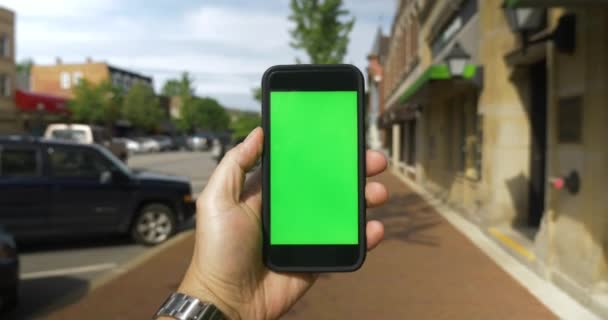 POV Caminhando em Cidade Pequena com Smartphone Tela Verde — Vídeo de Stock