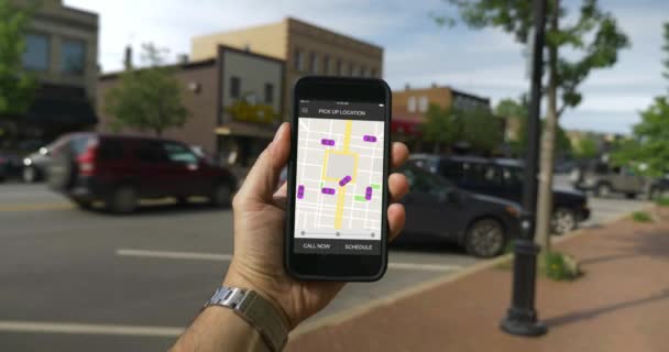 Hombre mira en paseo compartir patrones de tráfico en el teléfono inteligente en la ciudad pequeña — Vídeos de Stock