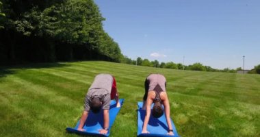 İki Millennials Yoga pozisyonları dışında gerçekleştirme