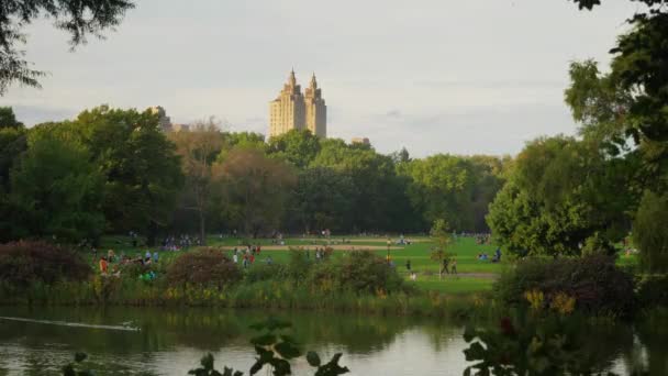 Люди наслаждаются природой в Центральном парке ранней осенью — стоковое видео