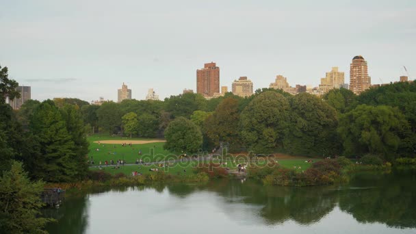 Mensen genieten van de natuur in Central Park op vroege herfst avond — Stockvideo