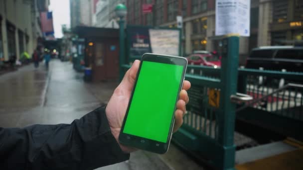 男を保持するマンハッタンの地下鉄の入り口で緑スクリーンのスマート フォン — ストック動画