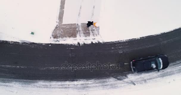Aus der Vogelperspektive: Hausbesitzer schaufelt Schnee von Einfahrt — Stockvideo
