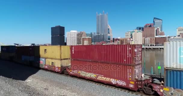 ピッツバーグ 2018 貨物列車としてピッツバーグのスカイラインのゆっくりと進む上昇空中確立ショットをフォア グラウンドで渡します 遠くにハインツ フィールド — ストック動画