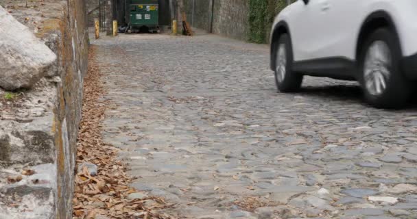 Auto fährt enge Kopfsteinpflasterstraße hinunter — Stockvideo