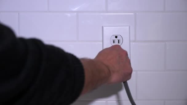 Man Plugs Cabo elétrico na tomada de cozinha — Vídeo de Stock