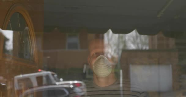 一个戴着面具的男人打开前门 看着外面一辆消防车经过 建议在2020年使用口罩来预防Covid 19病毒的传播 — 图库视频影像