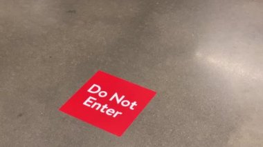 Alışveriş merkezindeki tek yönlü koridordan çıkan bir erkek müşterinin düşük açılı görüntüsü. Mağazalardaki koridorlardan biri, 2020 salgınında COVID-19 'un yayılmasını önlemek için ortak bir siteydi..  