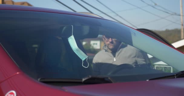 Чоловік Сідає Машину Кладе Маску Обличчя Перш Ніж Вийти Вулицю — стокове відео