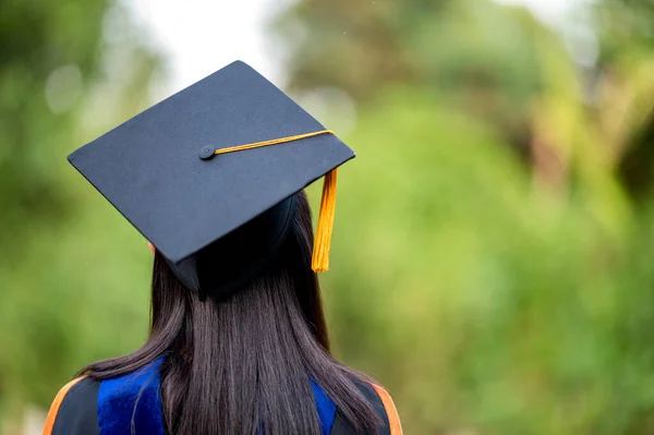 黒のフリンジのガウンと黒の帽子を身に着けている女性の大学卒業生の後ろのクローズアップ 高校での教育の成功の概念 学位を祝福 — ストック写真