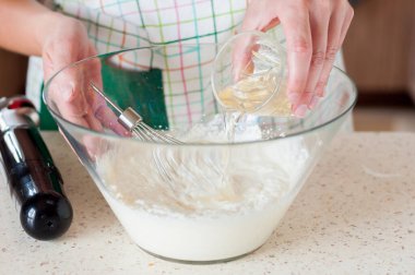 Cheesecake karışımlı bir kaseye jelatin ekleyen kadın