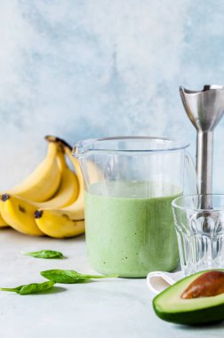 Sağlıklı Yeşil Meyve Smoothie Avokado, Muz ve Ispanak 'tan bir ölçü kabında bir el blenderi ile harmanlanmış, metin alanınız için kopyalama alanı