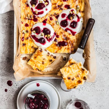 Ekşi kremalı ve kiraz soslu tatlı peynir keki, kare.