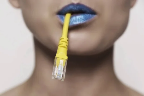 Bir ağ kablosu ağzına tutan bir kadın yüzü Close-Up — Stok fotoğraf