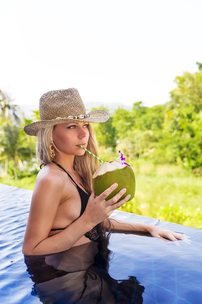 젊은 금발 여 자가 모자 음료 건강 한 해독을 코코넛 주스 슬림 — 스톡 사진