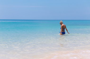 Tropic üzerinde açık suda yüzen çok ince sarışın genç kadın