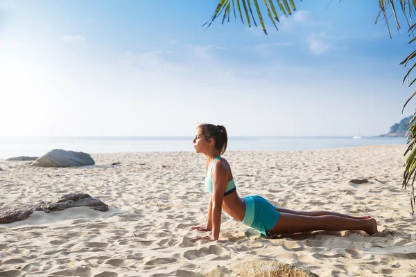 Junge ziemlich schlanke brünette Frau üben Yoga-Pose tropischen Strand — Stockfoto