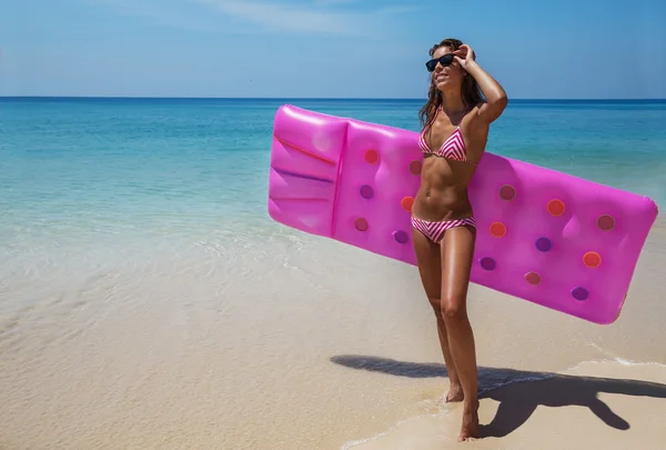 Brünette Frau sonnt sich mit Luftmatratze am tropischen Strand — Stockfoto